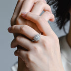a woman's hand wearing a round brilliant halo lab created diamond ring with pave band alongside a matching eternity ring