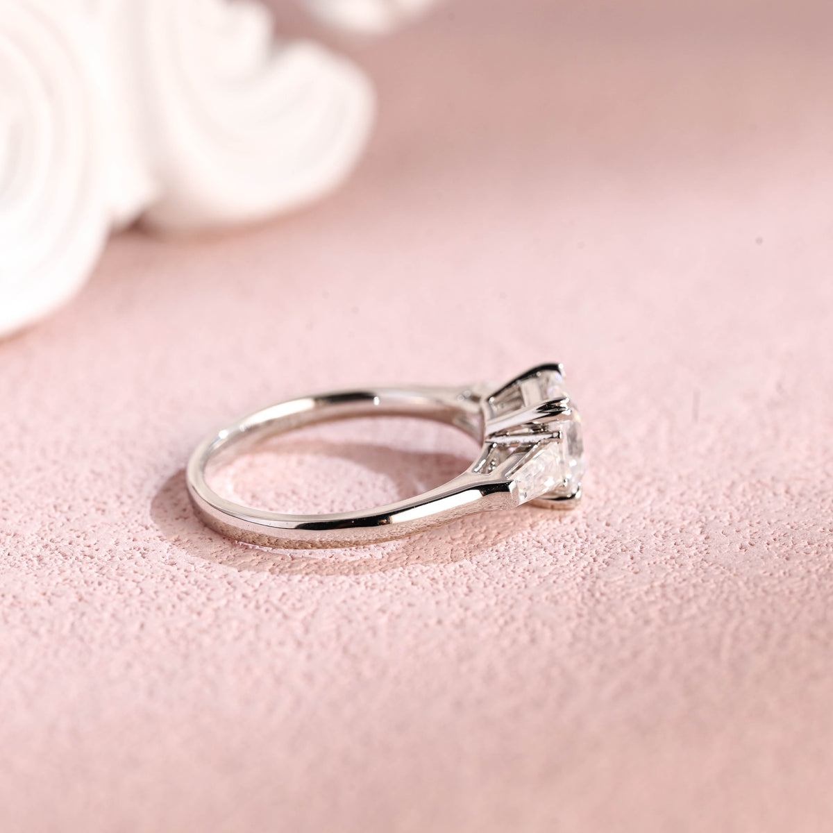 Side profile of a modern asscher cut lab diamond engagement ring with side stones.