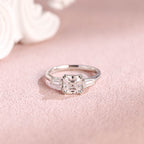 Front view of an IGI certified asscher cut lab grown diamond ring with side stones on a pink background.