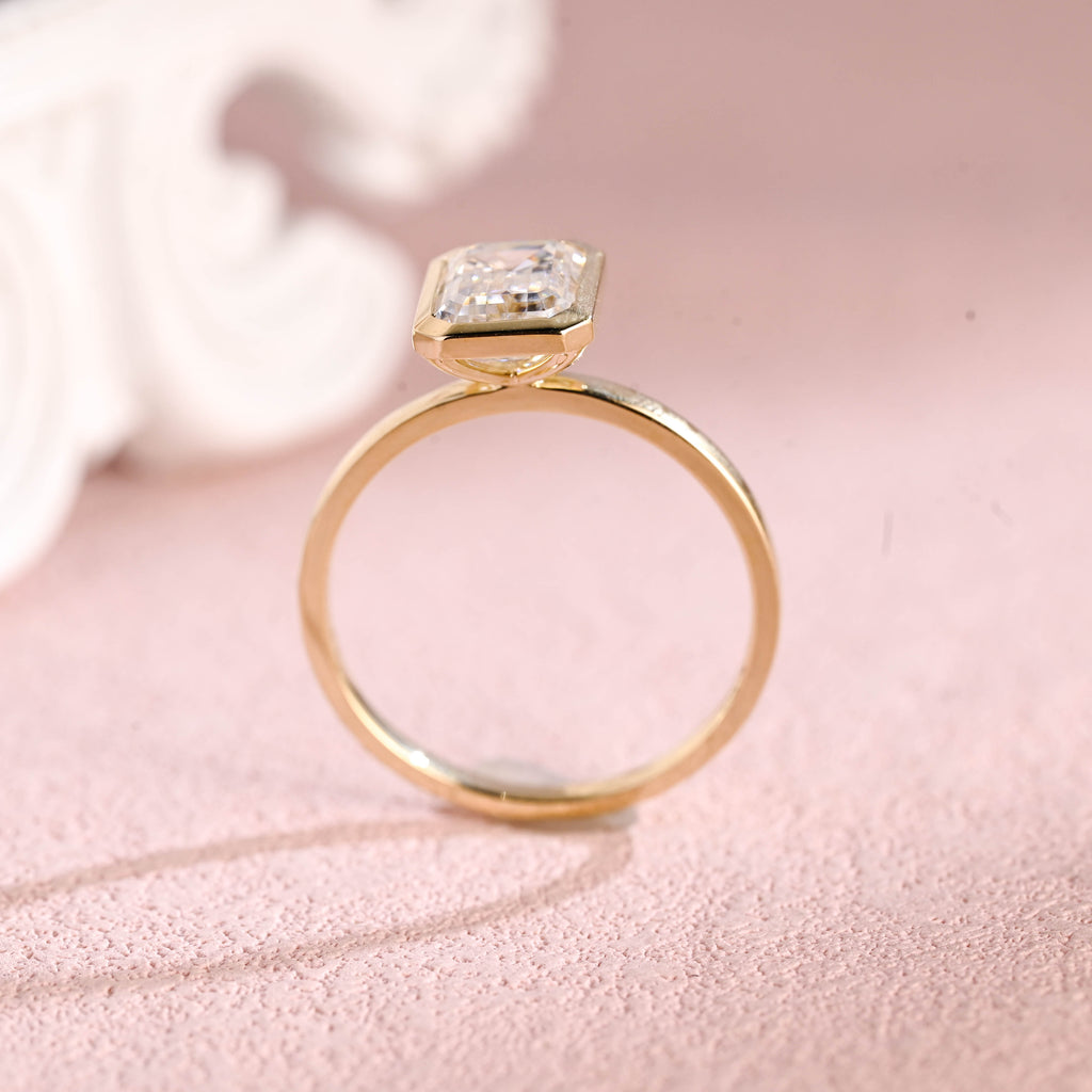 Close up angle shot highlighting the clean step-cut facets of an emerald lab diamond ring.
