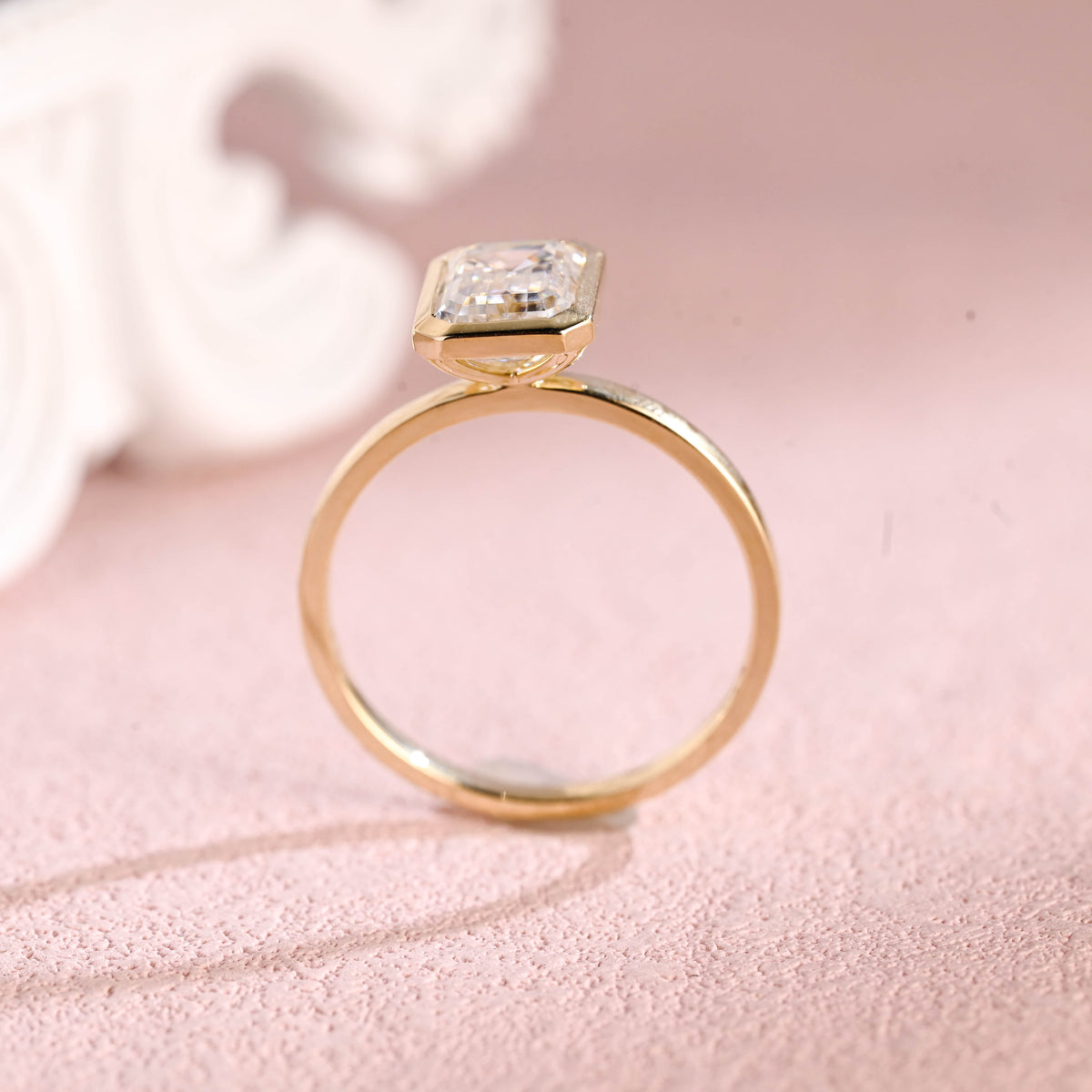 Close up angle shot highlighting the clean step-cut facets of an emerald lab diamond ring.