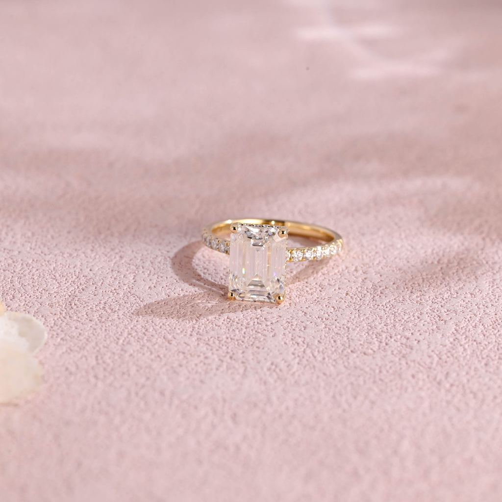 A luxurious emerald cut lab grown diamond engagement ring with micro-pave accent stones on the band and a d color vs1 center stone in white gold.