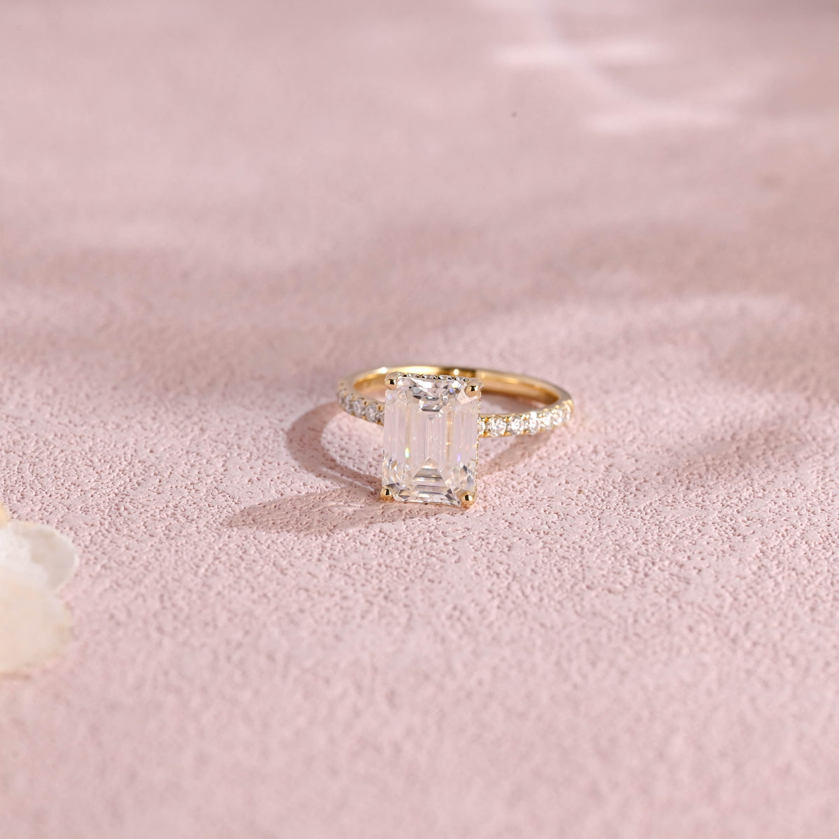 A luxurious emerald cut lab grown diamond engagement ring with micro-pave accent stones on the band and a d color vs1 center stone in white gold.