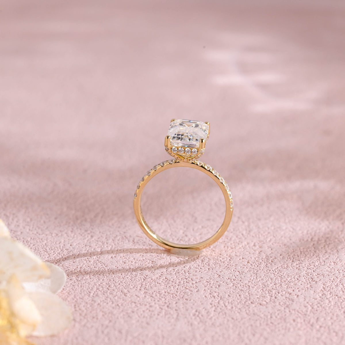 A luxurious emerald cut lab grown diamond engagement ring with micro-pave accent stones on the band and a d color vs1 center stone in white gold.
