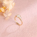 A classic 14k yellow gold three stone engagement ring featuring a large emerald cut lab grown diamond flanked by two step-cut side stones.