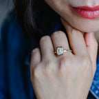 A model wearing a gorgeous bezel set emerald cut lab grown diamond ring on her finger.