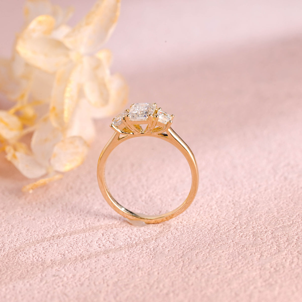 Side profile and macro view of an emerald cut lab created diamond ring showing the 4 prong basket setting and high polish solid white gold band.