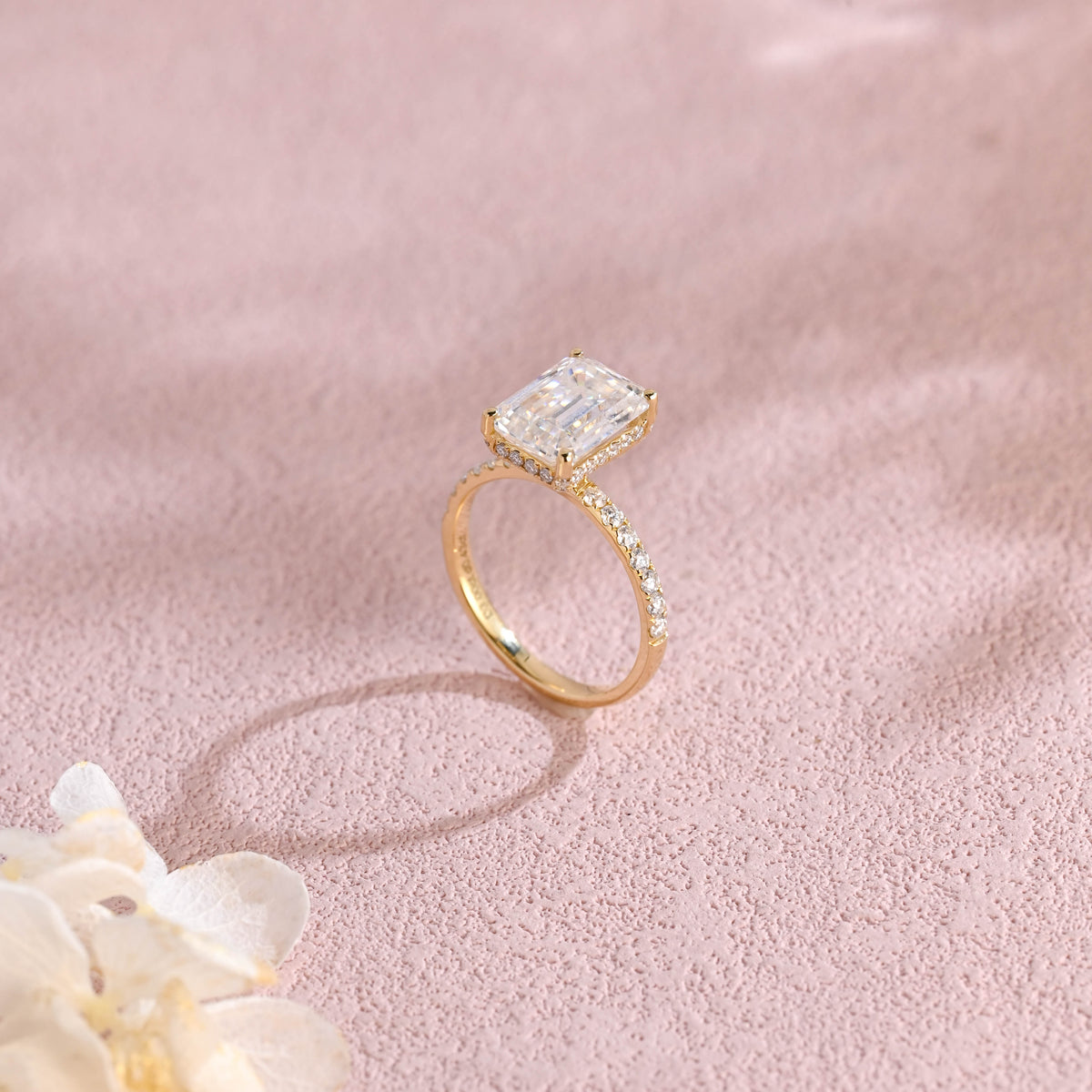 Side profile macro view of an emerald cut lab created diamond ring showing the intricate micro-pave basket and accent stones.