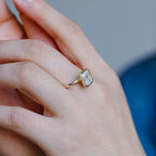 A model wearing a gorgeous bezel set emerald cut lab grown diamond ring on her finger.