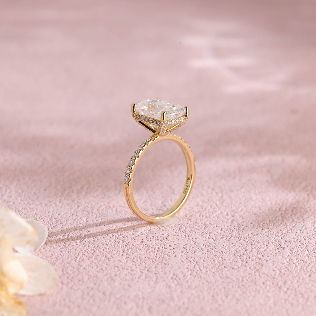 A luxurious emerald cut lab grown diamond engagement ring with micro-pave accent stones on the band and a d color vs1 center stone in white gold.