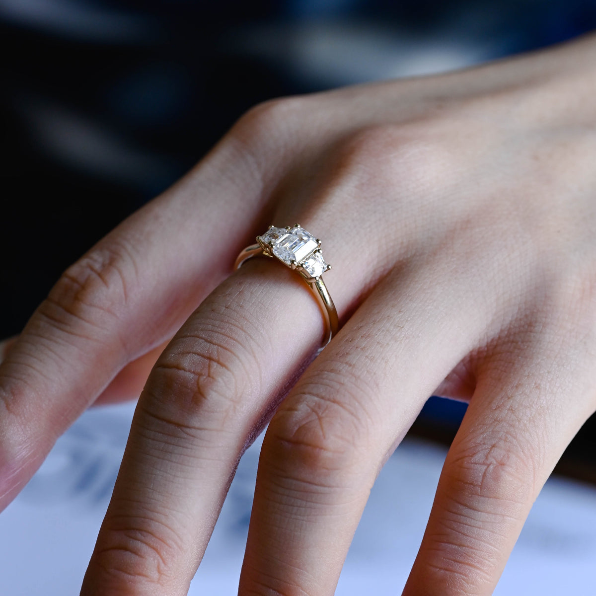 Premium ethical emerald cut lab grown diamond 3 stone ring showcased inside a luxury gift box with official IGI certification papers.
