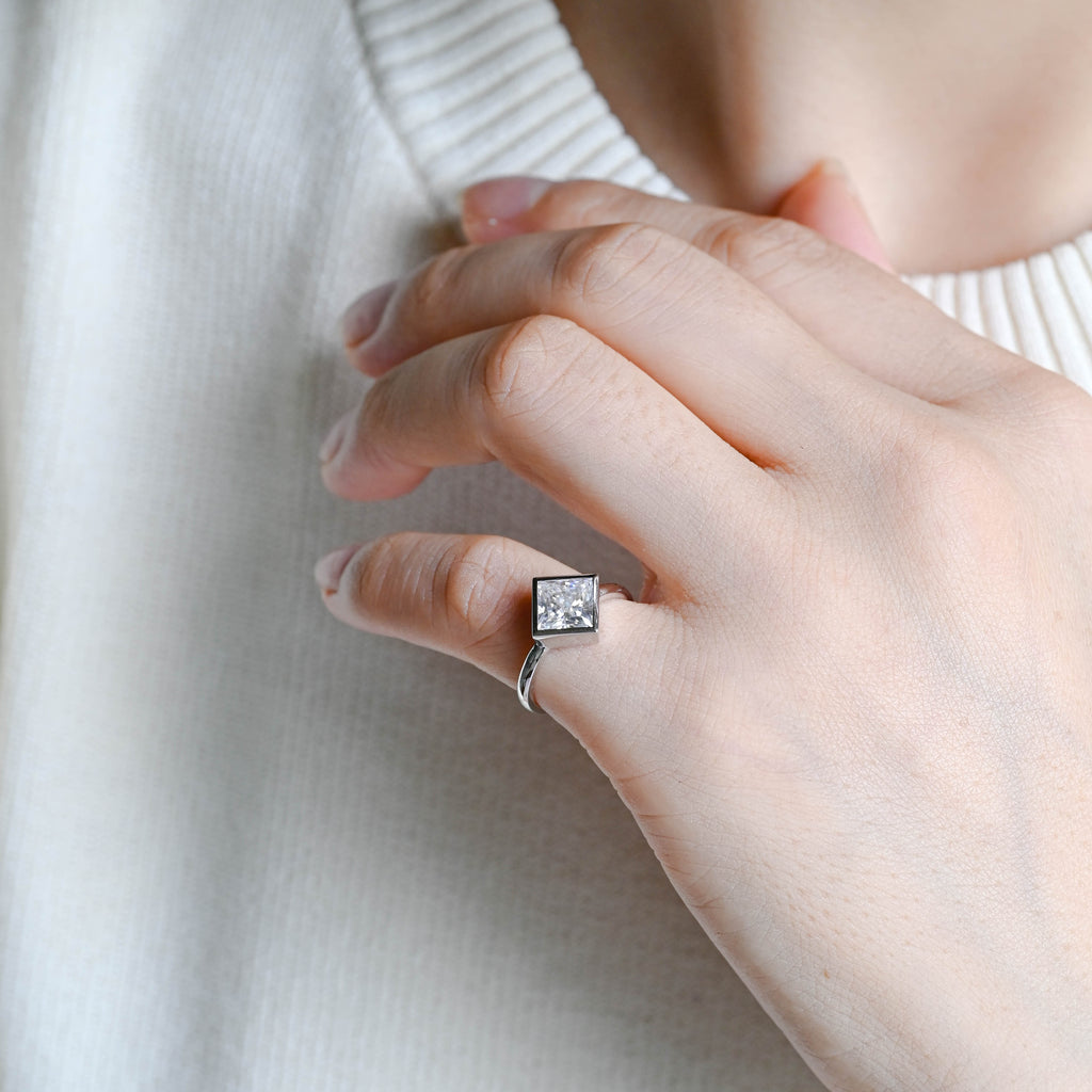 Premium princess cut lab grown diamond bezel engagement ring showcased with a luxury gift box and official independent IGI certificate papers.