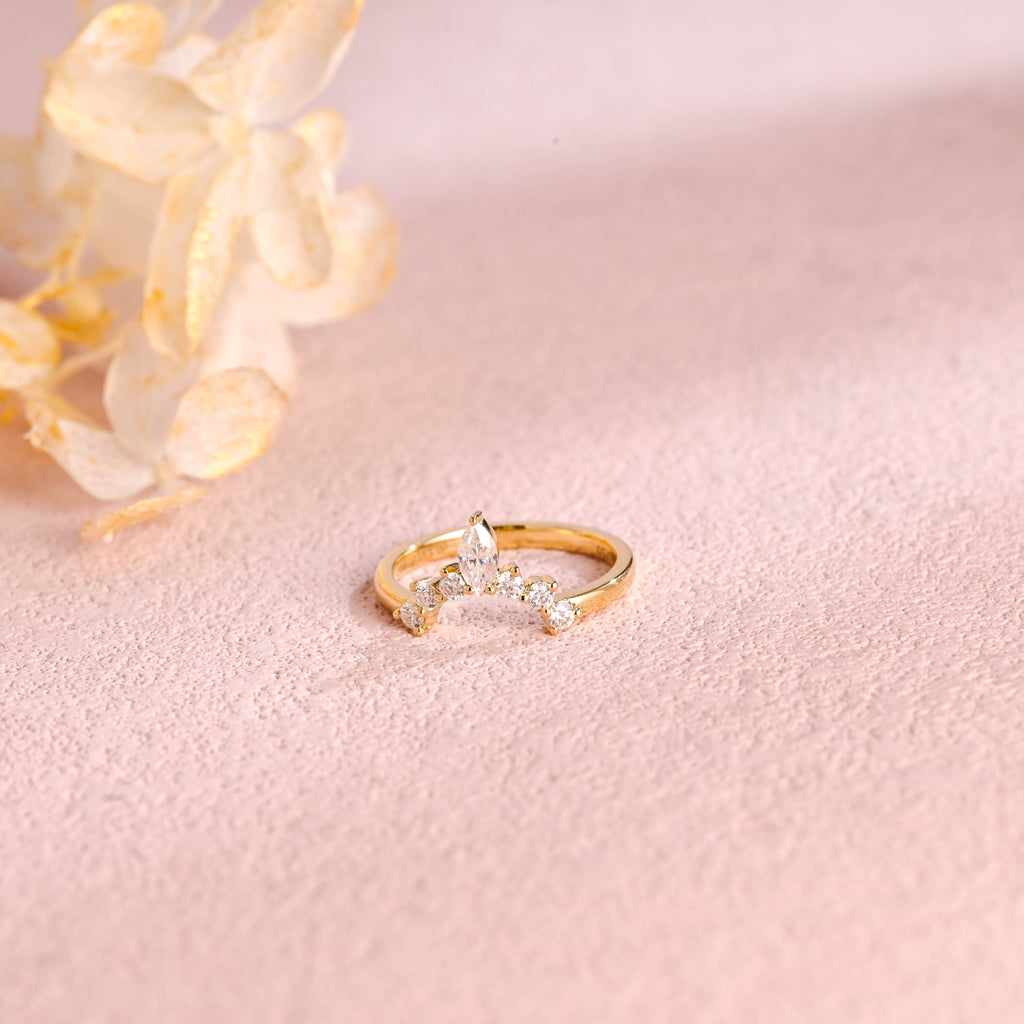 A dainty 14k yellow gold alternating marquise and round lab grown diamond band 0.3 ctw on a neutral background.