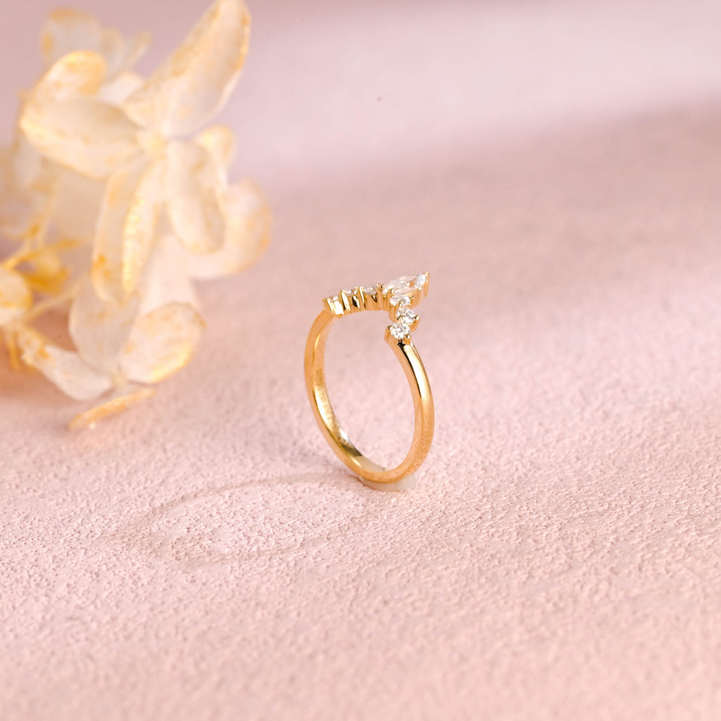 A dainty 14k yellow gold alternating marquise and round lab grown diamond band 0.3 ctw on a neutral background.