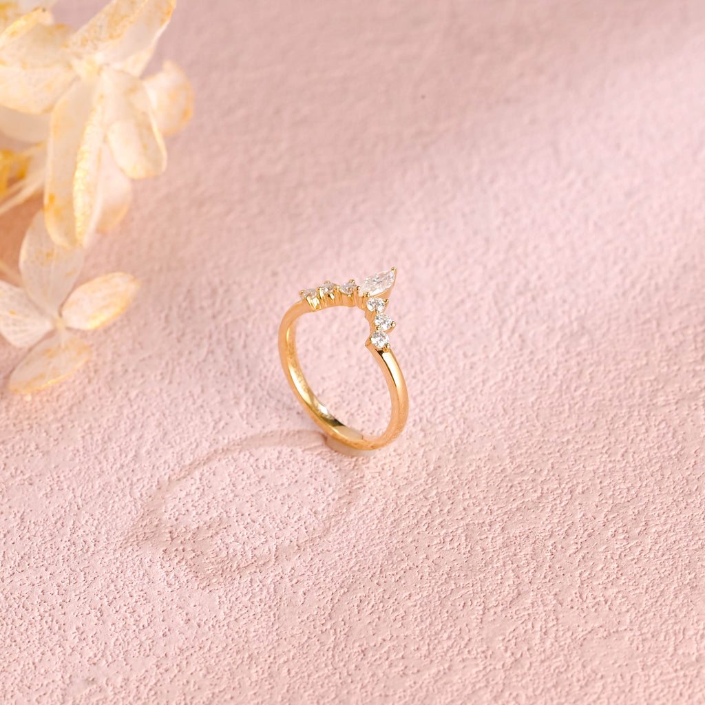 Side profile view of a marquise and round lab created diamond cluster stacking ring showing individual prong settings in white and rose gold.