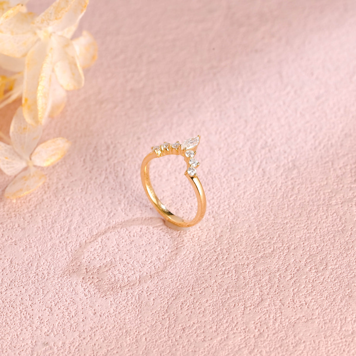 Side profile view of a marquise and round lab created diamond cluster stacking ring showing individual prong settings in white and rose gold.