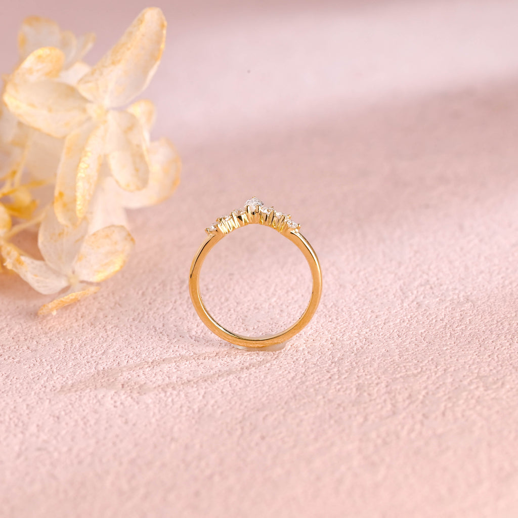 A dainty 14k yellow gold alternating marquise and round lab grown diamond band 0.3 ctw on a neutral background.