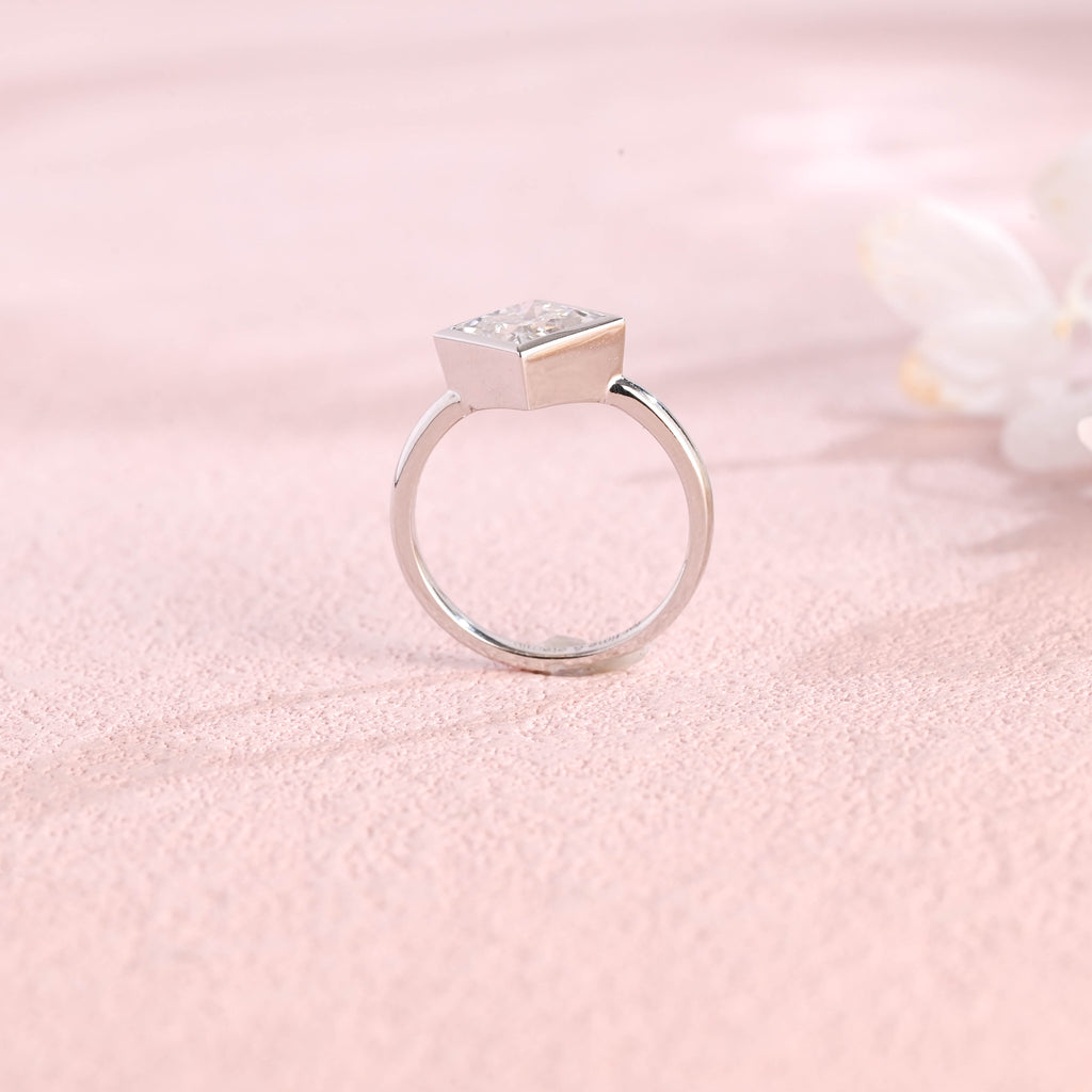 A minimalist 14k yellow gold princess cut lab grown diamond engagement ring featuring a sleek full bezel setting with a d color vs1 center stone.