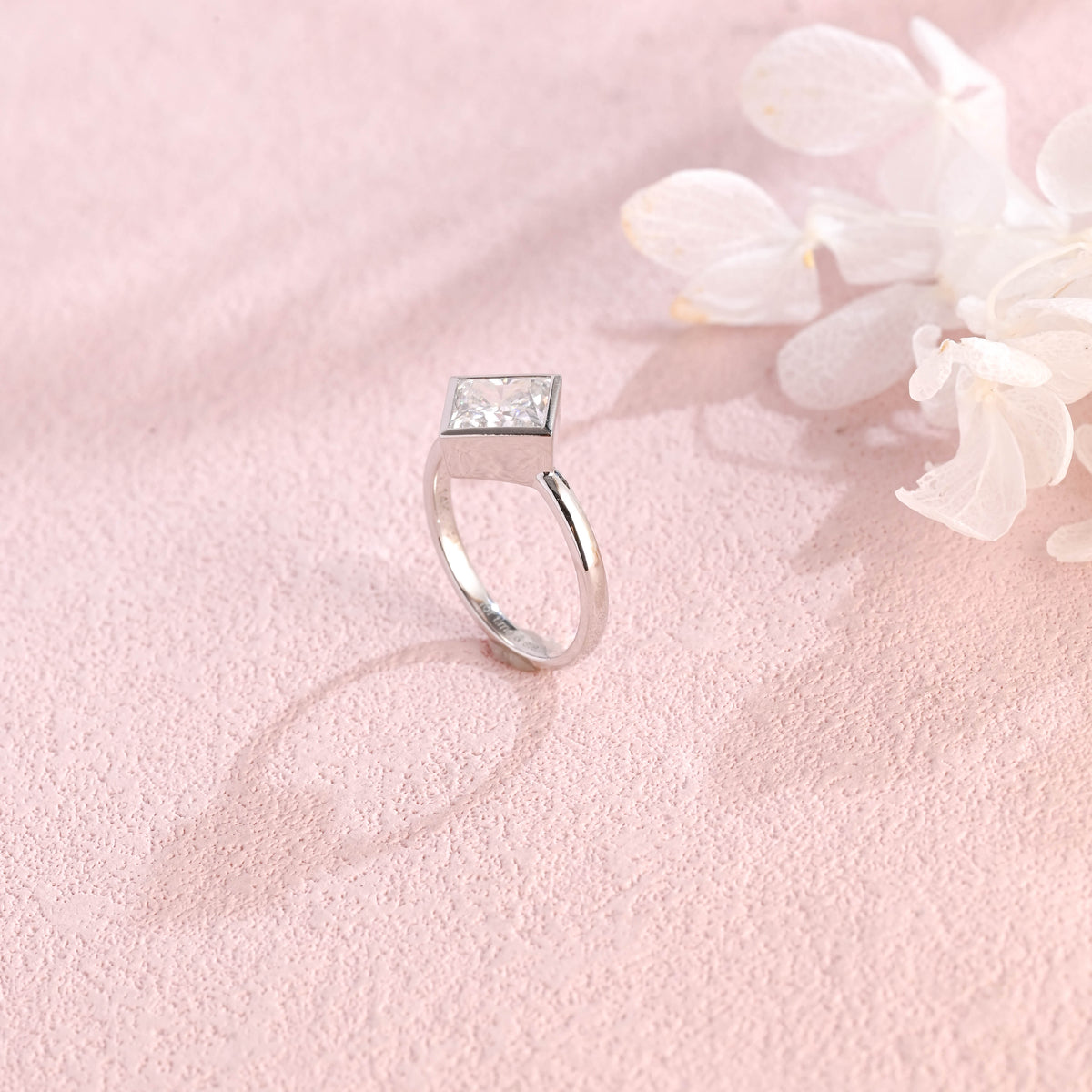 Side profile view of a modern princess cut lab created diamond full bezel setting showing the low-profile solid metal band design.