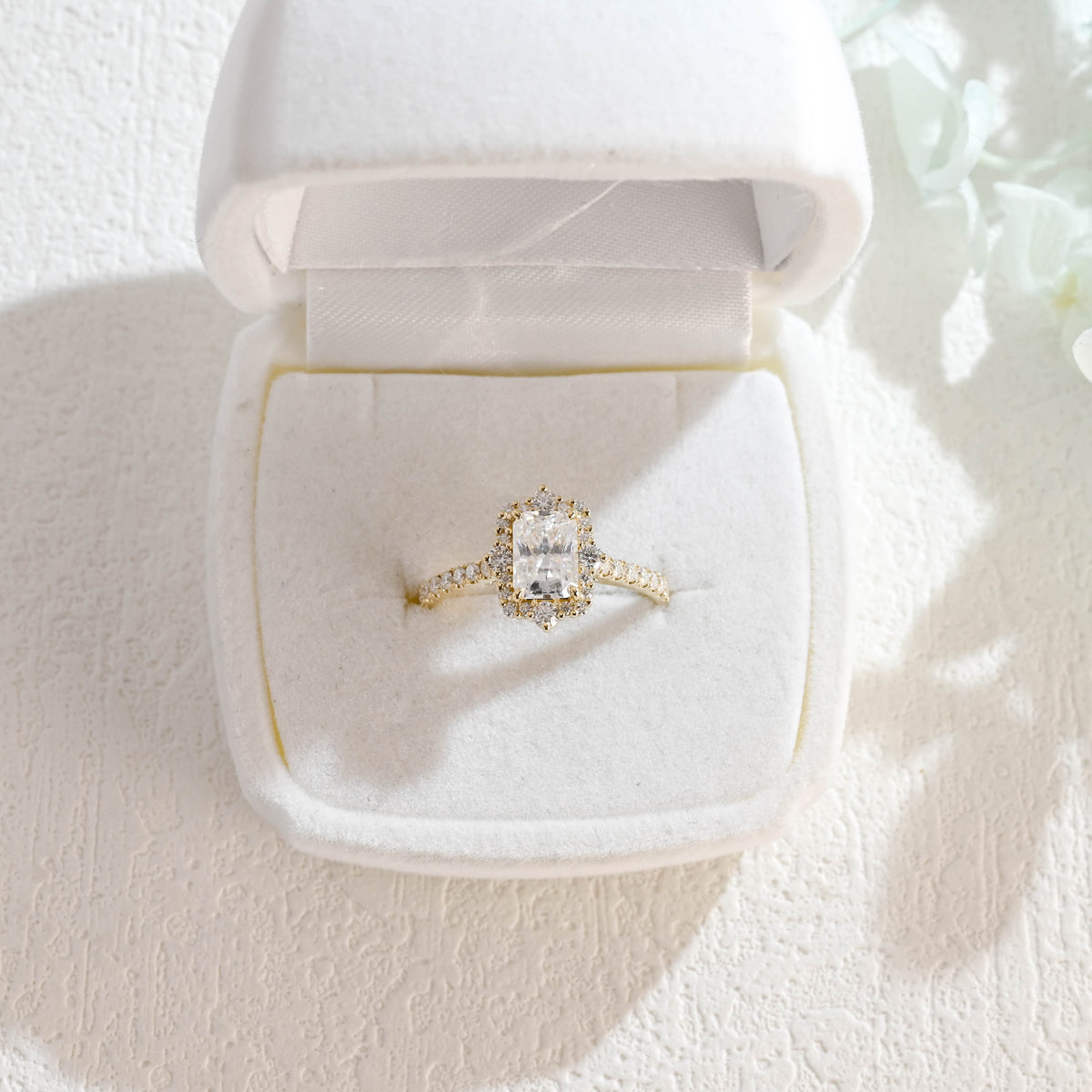 A luxurious radiant cut lab grown diamond engagement ring featuring a micro-pave halo and pave band with a d color vs1 center stone in white gold.