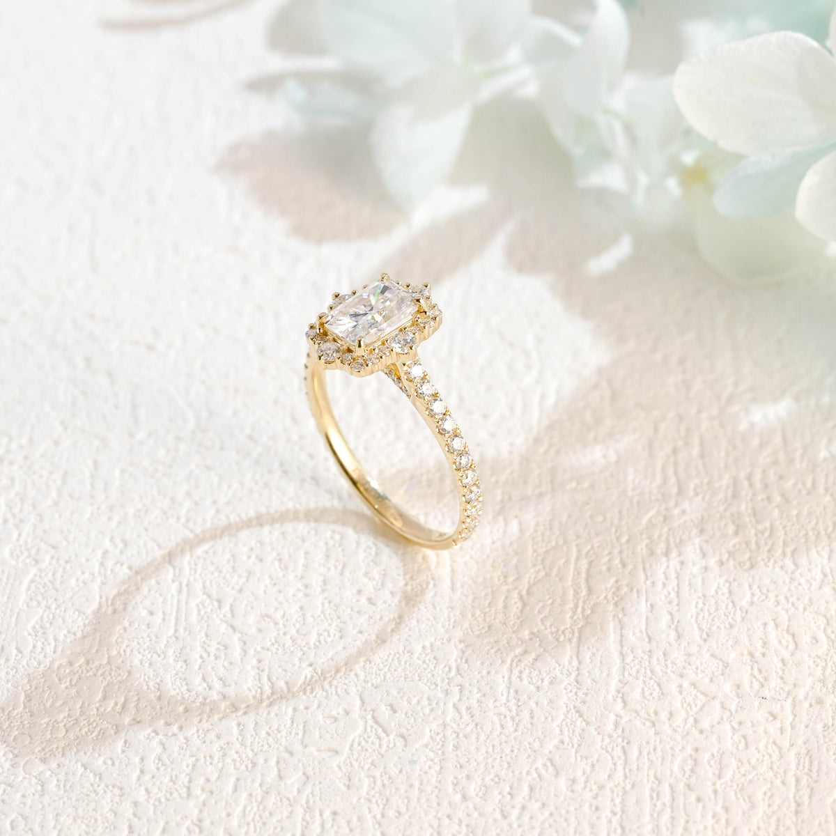 A luxurious radiant cut lab grown diamond engagement ring featuring a micro-pave halo and pave band with a d color vs1 center stone in white gold.