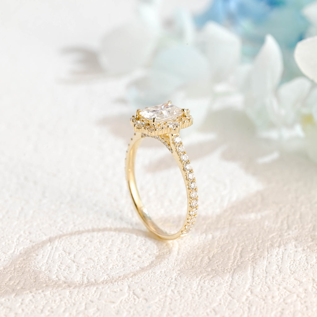 A luxurious radiant cut lab grown diamond engagement ring featuring a micro-pave halo and pave band with a d color vs1 center stone in white gold.